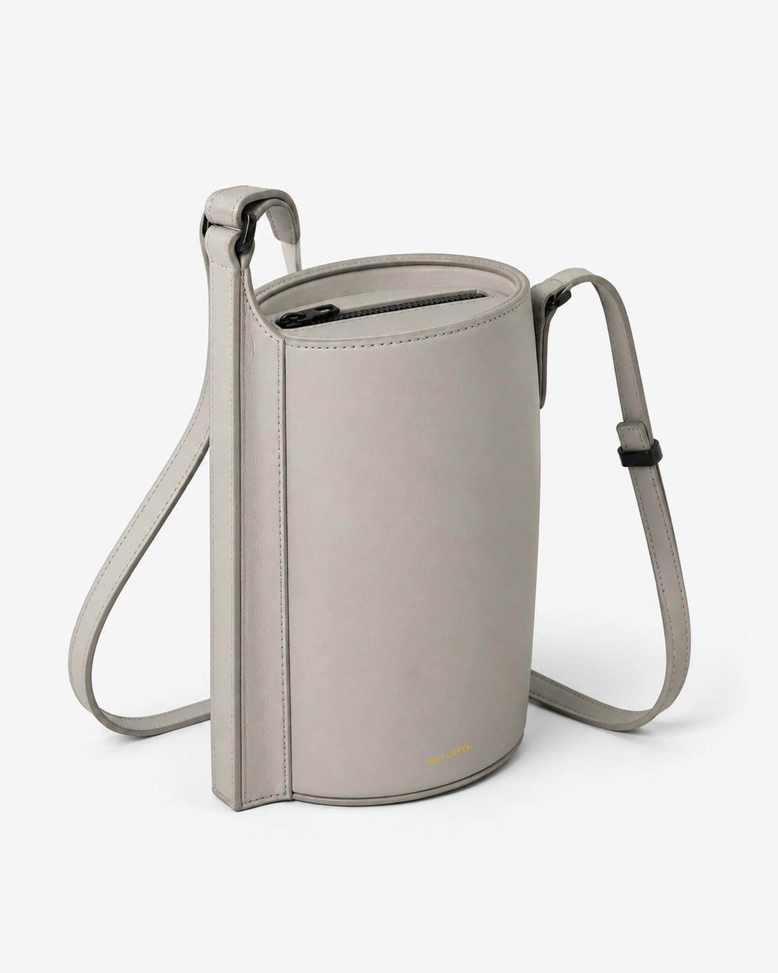 MUYLOTTA ML-CB05 bone gray cylinder crossbody bag, three-quarter view, with an oval cylinder and continuous side spine.