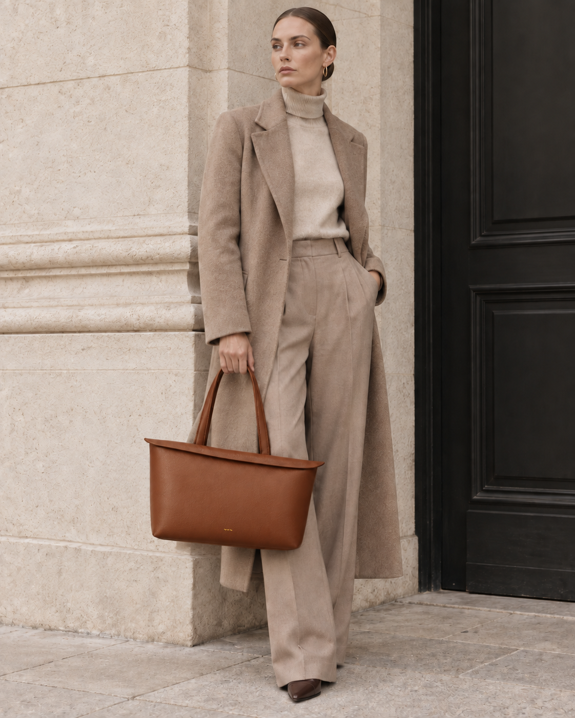 Model carrying the MUY LOTTA Floating Eave Span Cognac leather tote.