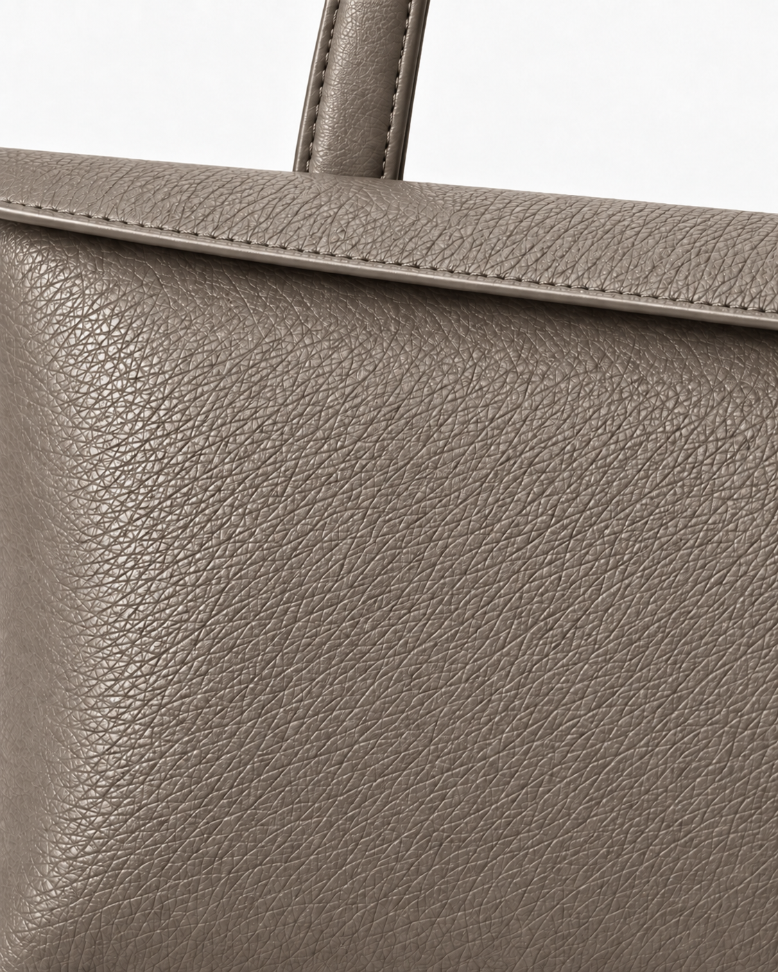 Close-up of the fine-grain Limestone Taupe surface of the MUY LOTTA Floating Eave Span tote.