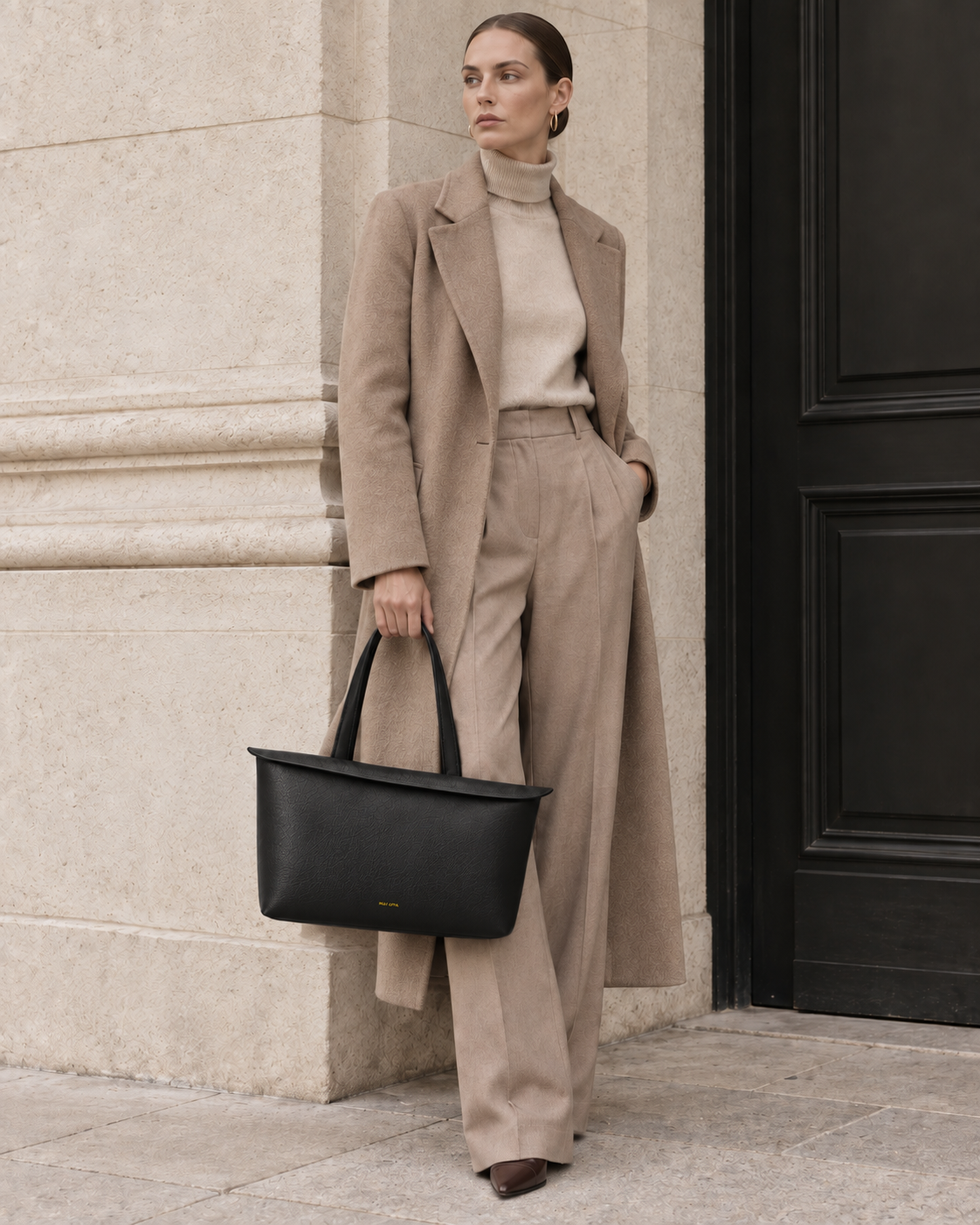 Model carrying the MUY LOTTA Floating Eave Span Soft Black leather tote.